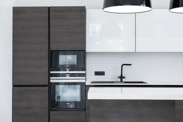 Modern kitchen with dark cabinets and built-in ovens