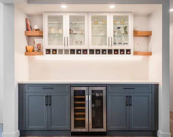 Built-in bar with glass cabinets, floating shelves and a wine fridge