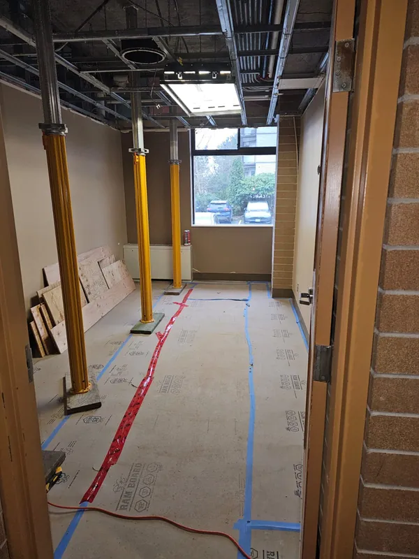 Corridor during the structural work, with temporary shoring posts and floor protection