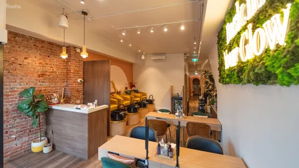 Salon interior with a brick wall, pedicure chairs and a moss sign